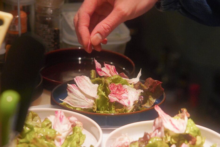 旬の野菜を丁寧に盛り付けるシェフの手元と彩り豊かなサラダ